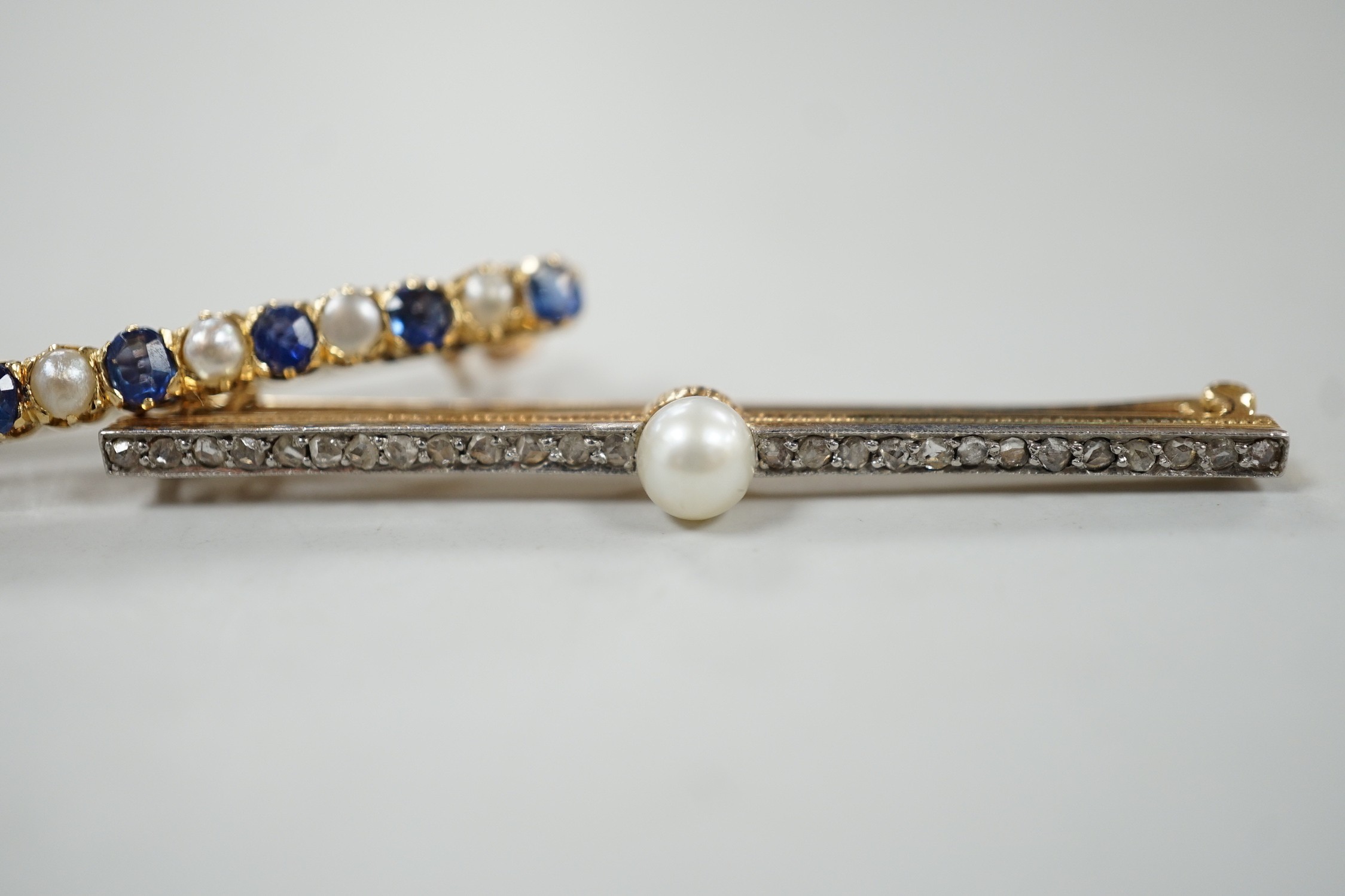 A 1920's yellow metal, cultured pearl and rose cut diamond set bar brooch, 47mm and a later yellow metal, split pearl and sapphire set bar brooch, gross weight 6.2 grams.